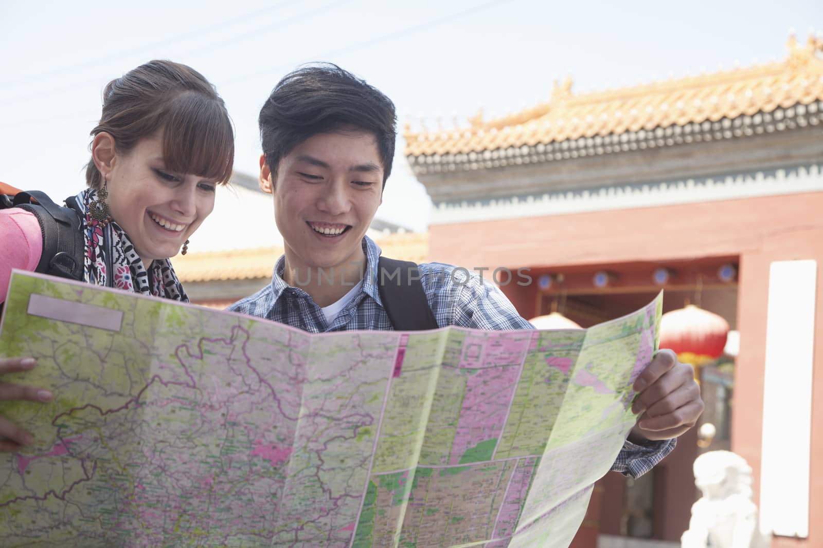 Young couple looking at map.  by XiXinXing