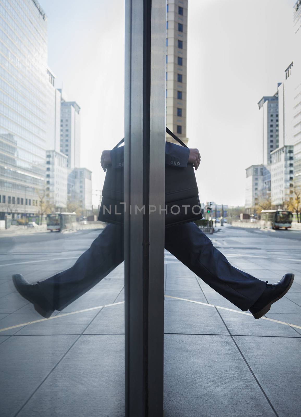 Businessman stepping out into the street, reflection in the glass of the building by XiXinXing