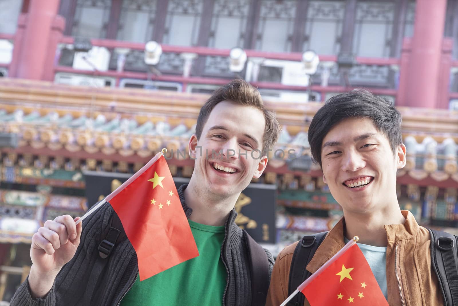 Two young men holding Chinese flags.