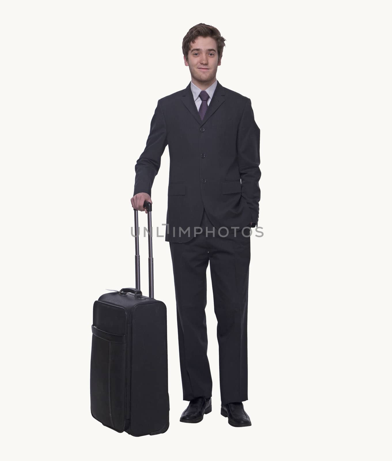 Portrait of smiling young businessman holding a suitcase, studio shot
