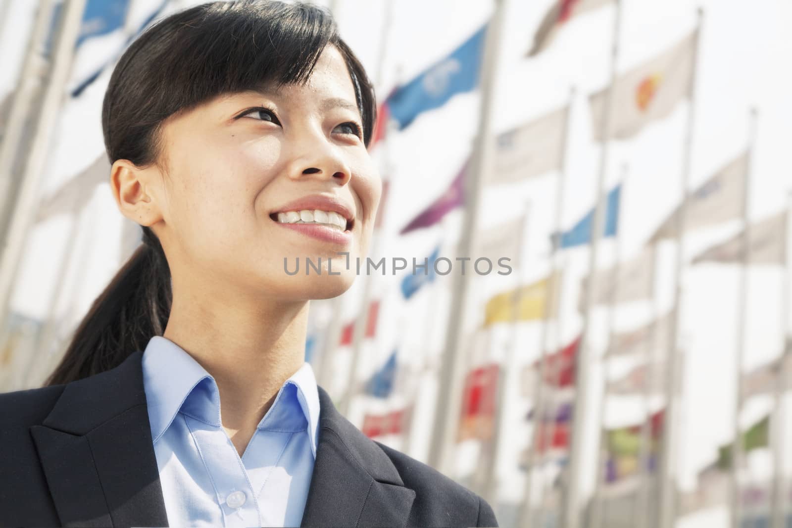 Close- up of young businesswoman standing and smiling by XiXinXing