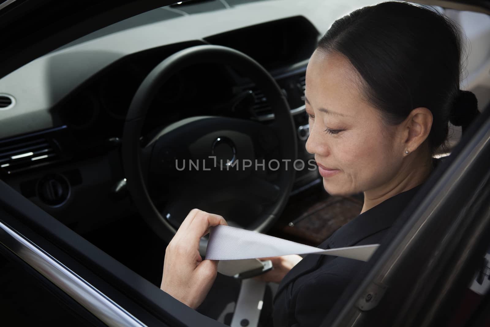 Mature businesswomen in car fastening seatbelt. by XiXinXing