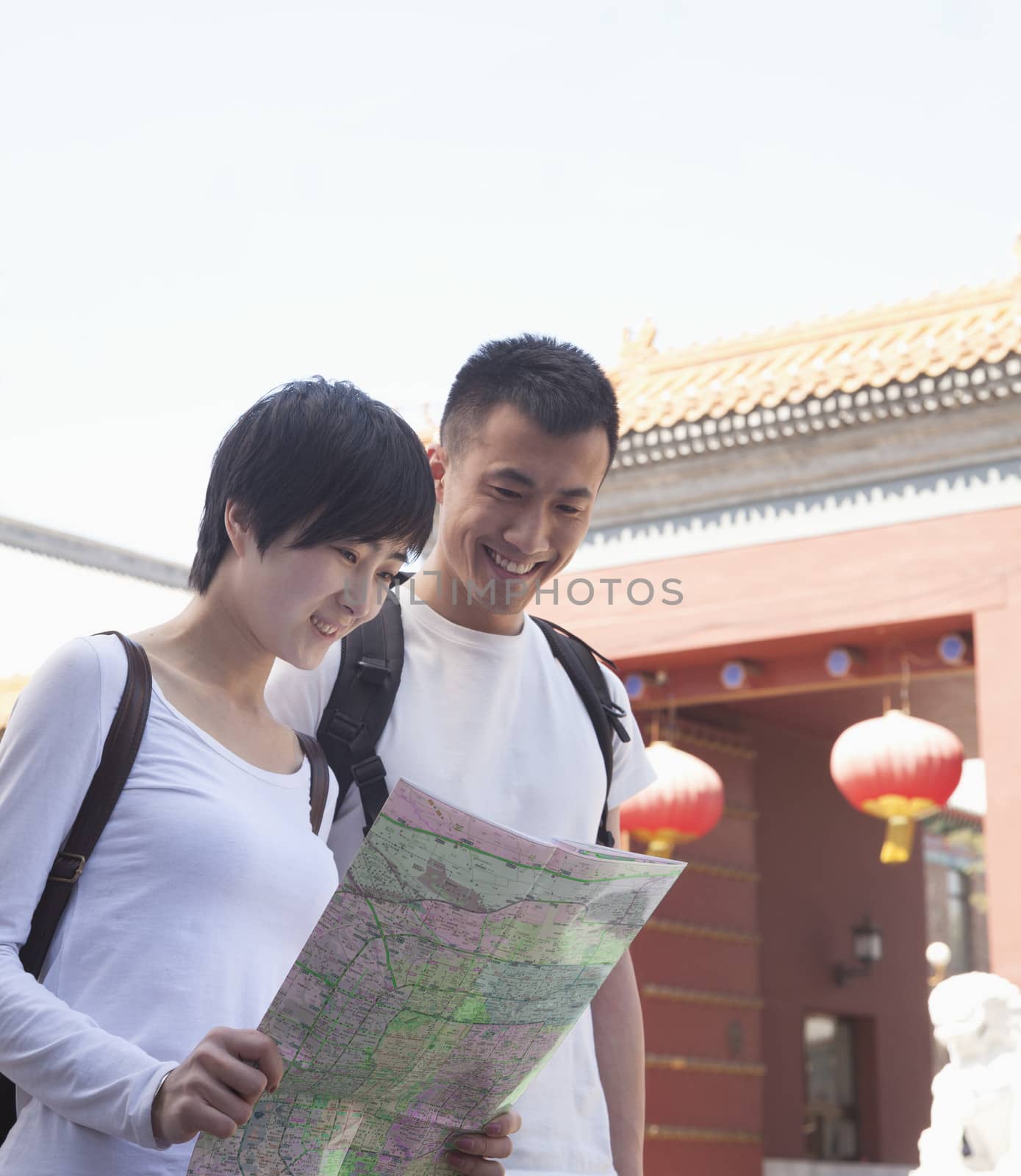 Young couple looking at map.  by XiXinXing