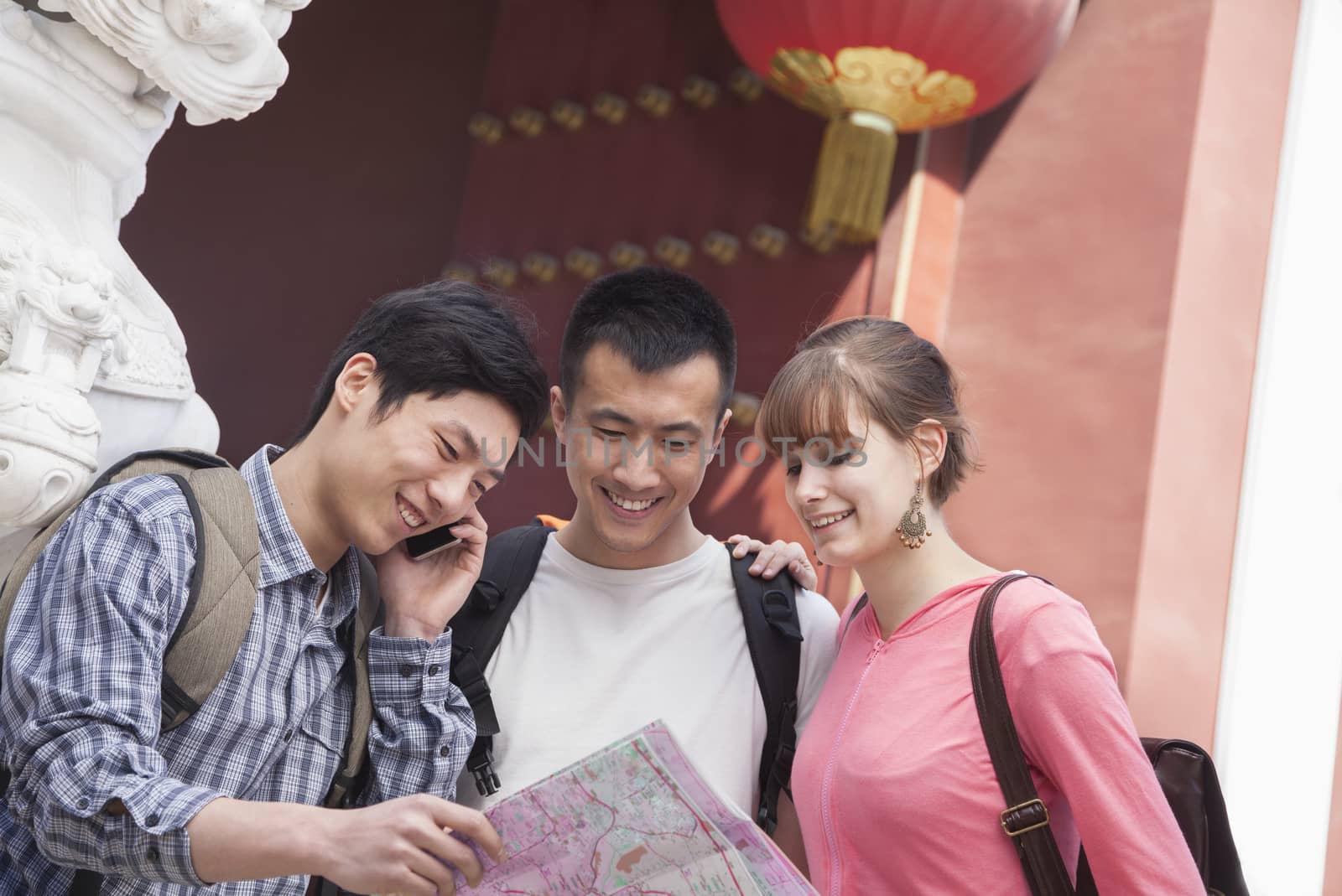 Three people looking at map.   by XiXinXing