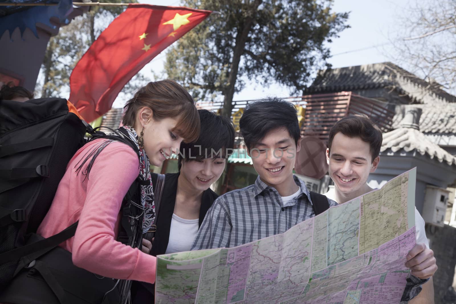 Four young people looking at map.