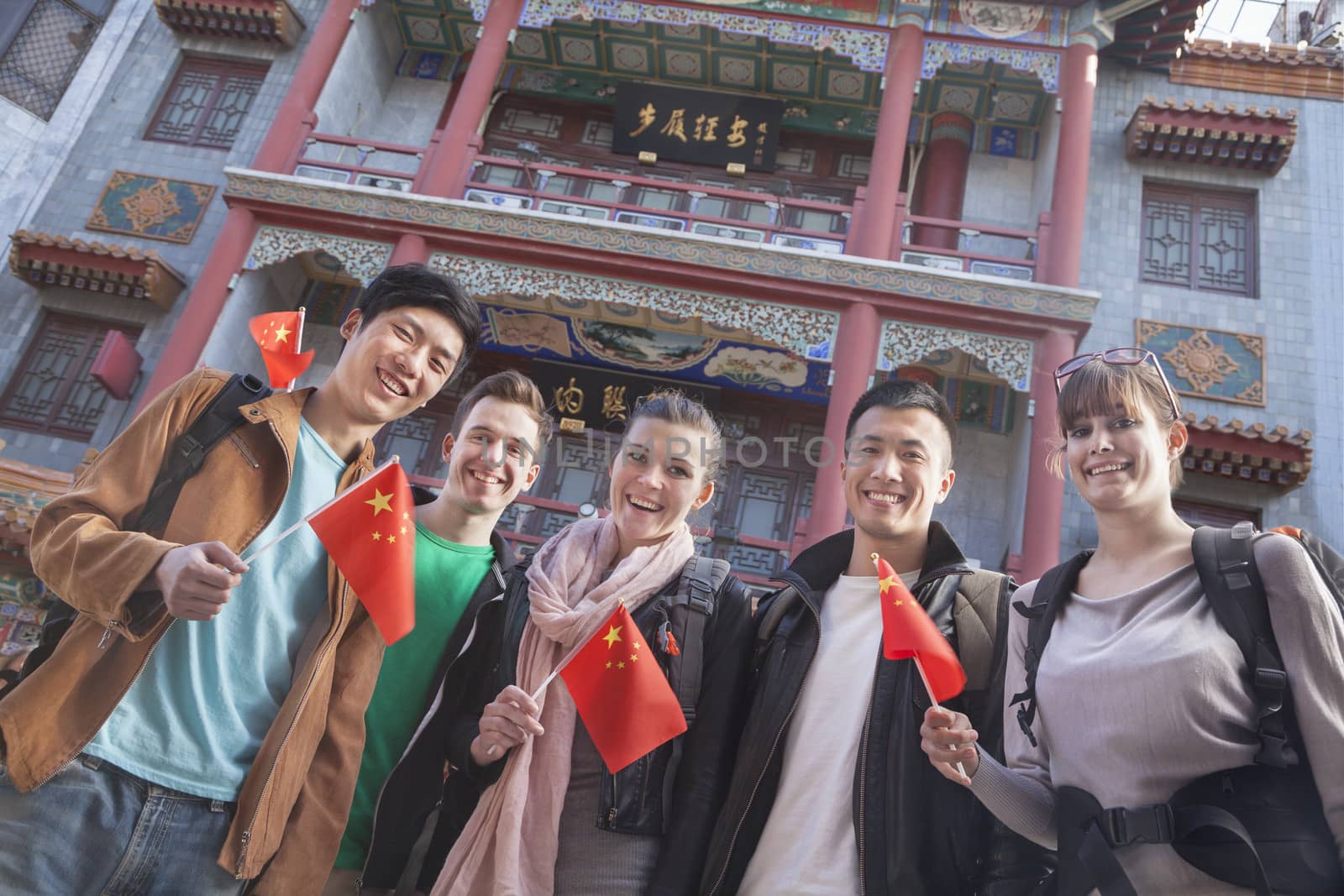 Group of young people holding Chinese flags, portrait.