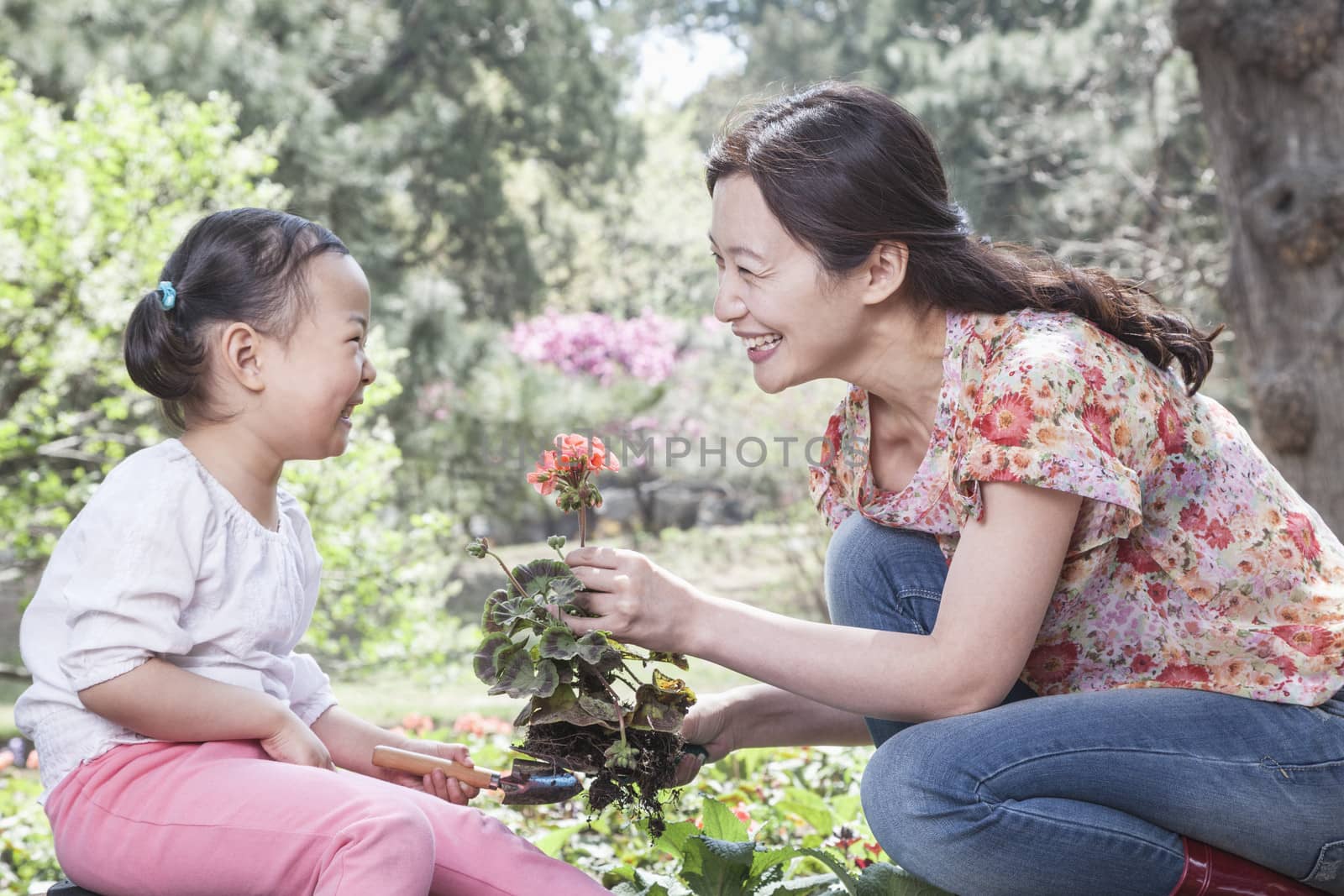 Mother and daughter planting flowers. by XiXinXing