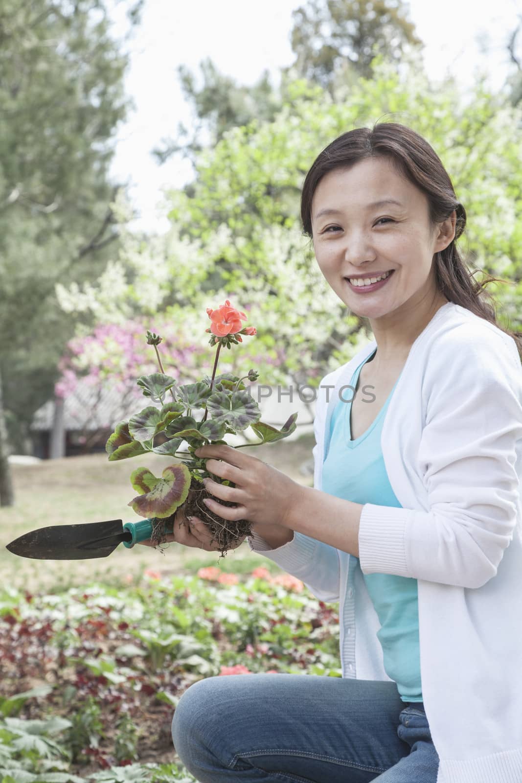 Portrait of woman planting flowers.  by XiXinXing