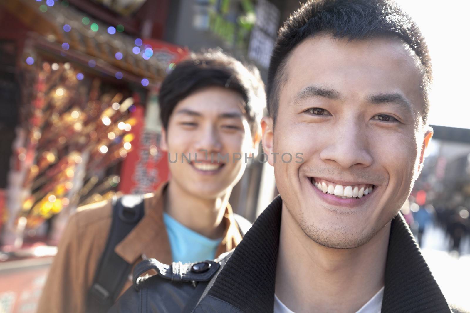 Two young men with Chinese Architecture in background.