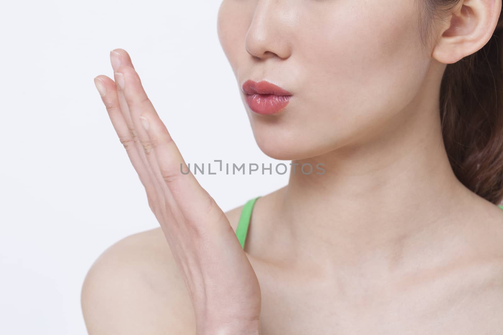 Close up of young woman blowing a kiss, studio shot 