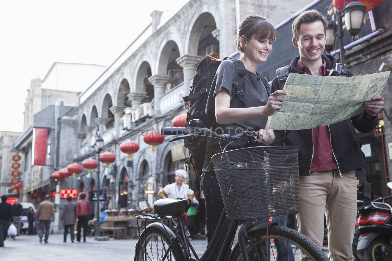 Young man and woman with bicycle and map. by XiXinXing