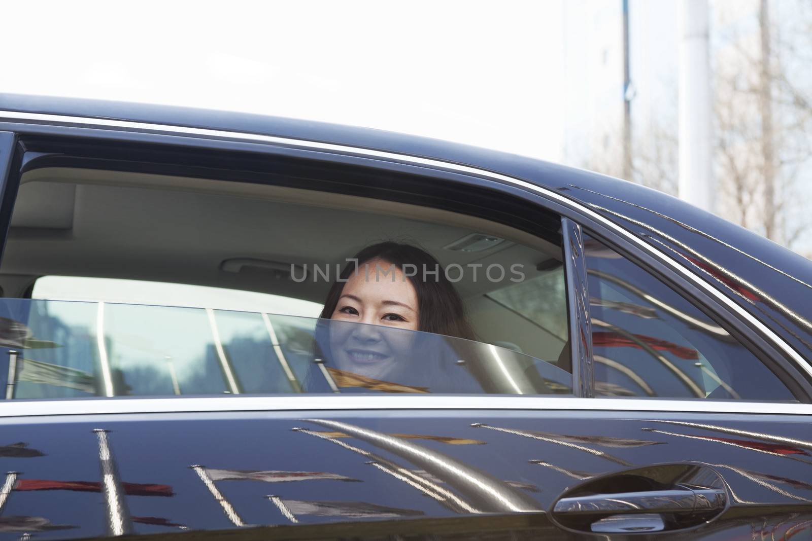 Young women in back seat of car looking out of window.
