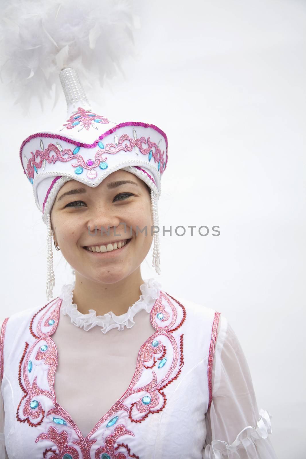 Portrait of young smiling woman in traditional clothing from Kazakhstan, studio shot