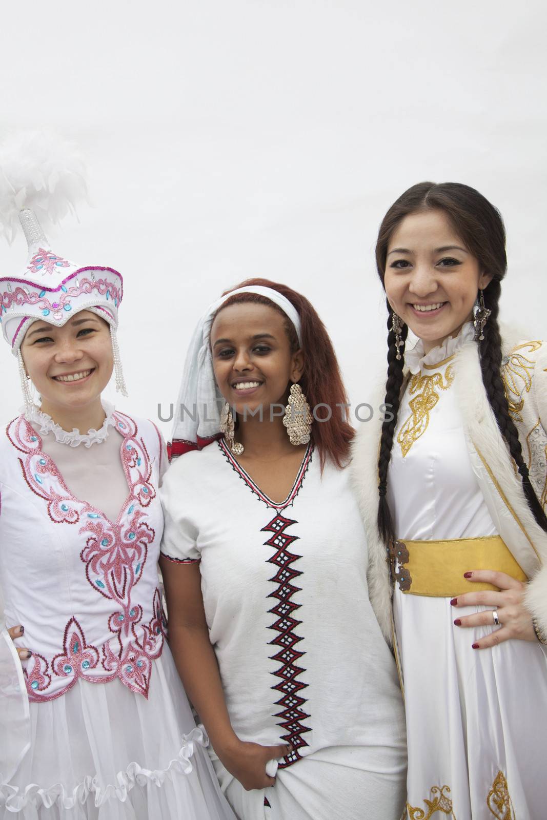 Portrait of three young multi-ethnic women in their traditional clothing, studio shot