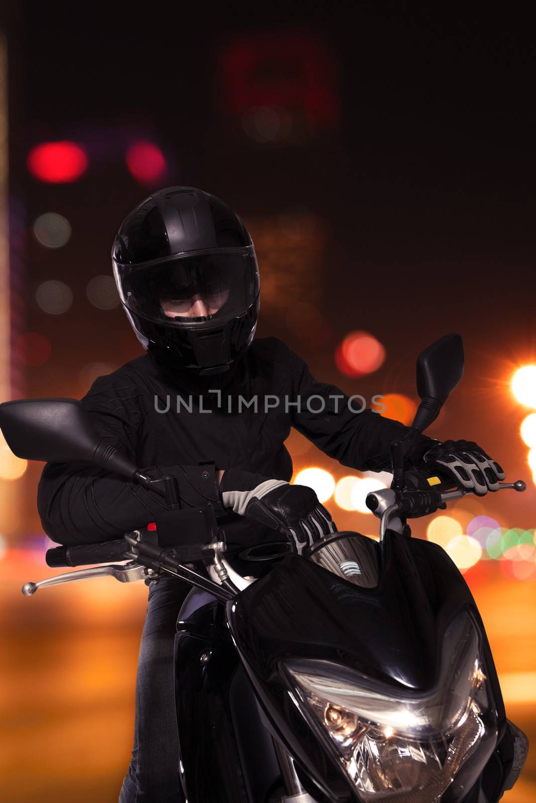 Young man sitting on his motorcycle at night in Beijing by XiXinXing