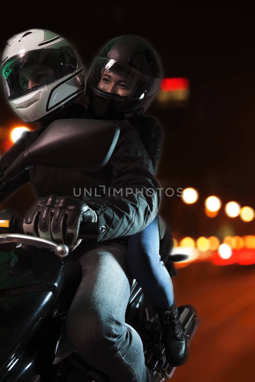 Young couple riding a motorcycle through the city streets at night in Beijing