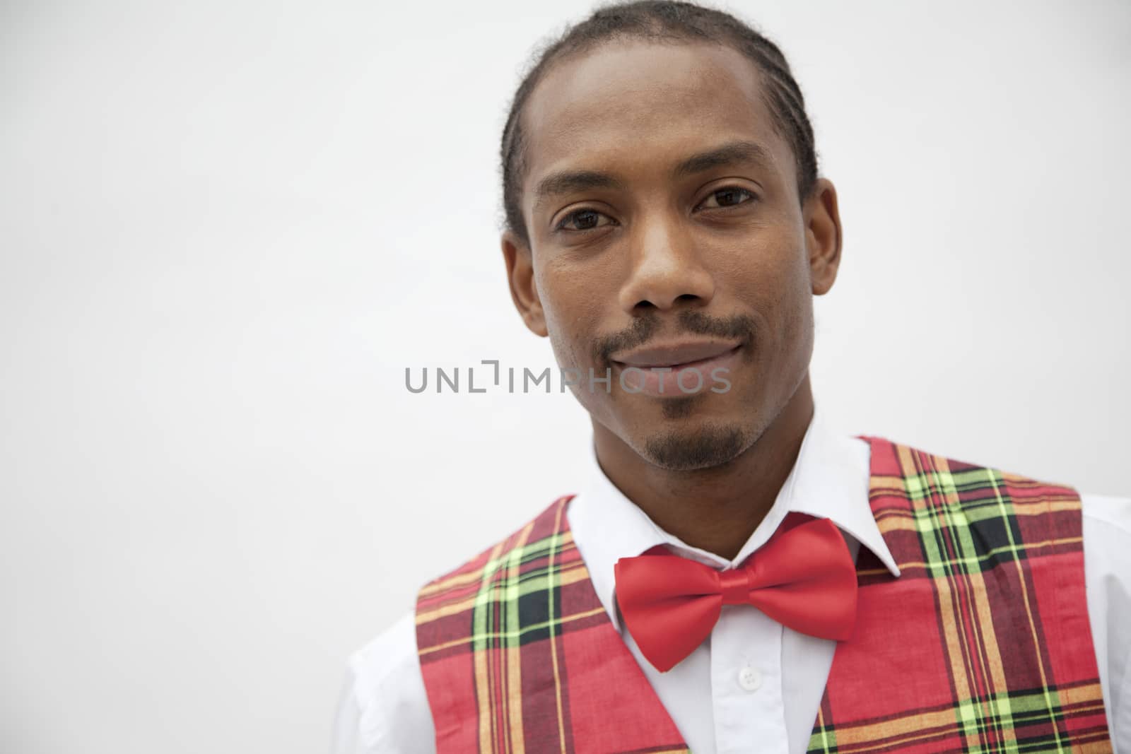 Portrait of young man in plaid vest and red bow tie, studio shot by XiXinXing
