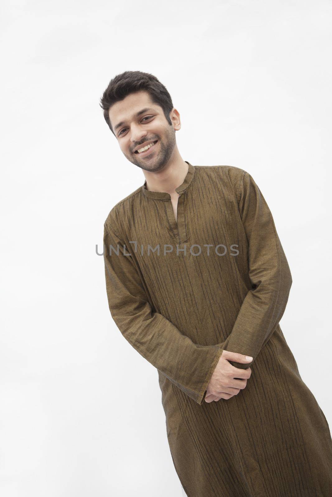 Portrait of smiling young man wearing traditional clothing from Pakistan, studio shot