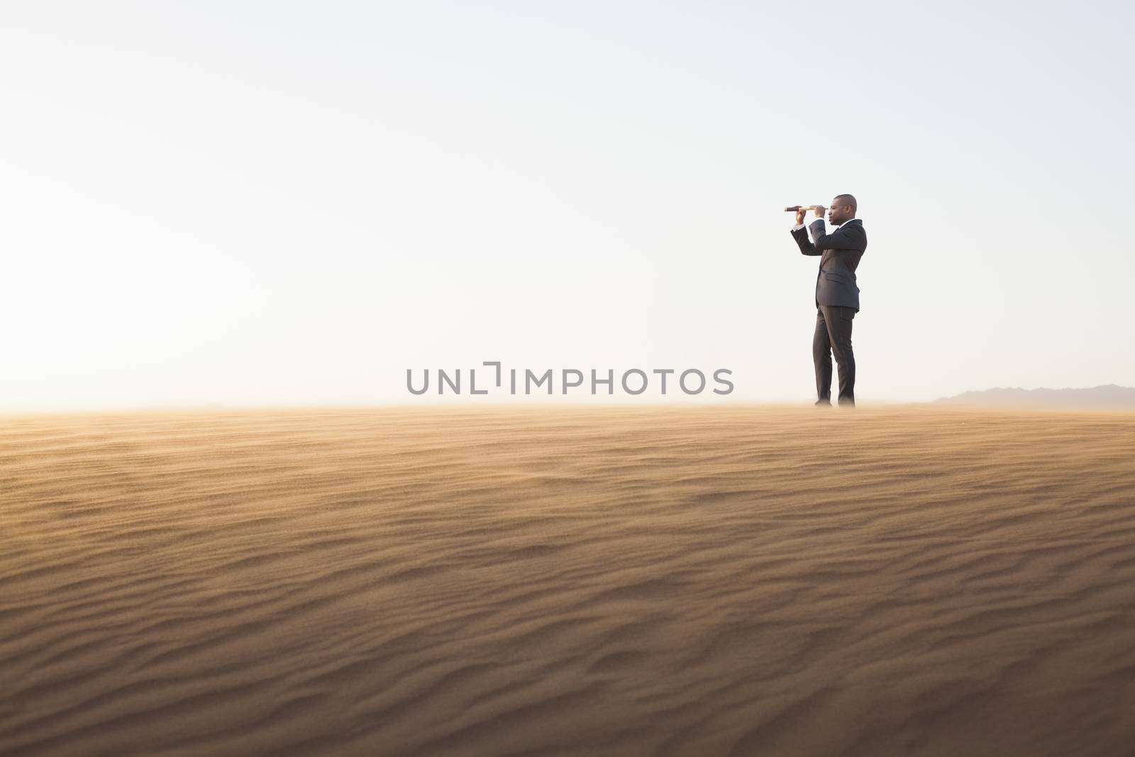 Young businessman looking through telescope in  the middle of the desert by XiXinXing