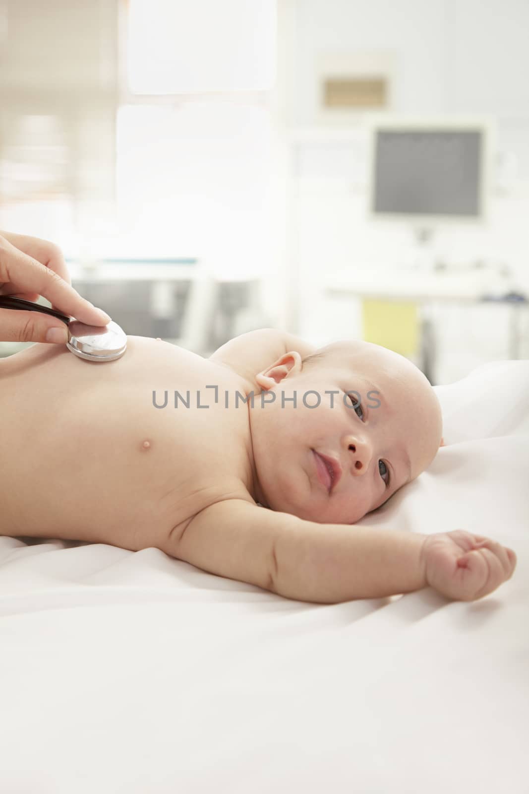Doctors hand checking the heartbeat of a baby, close-up  by XiXinXing