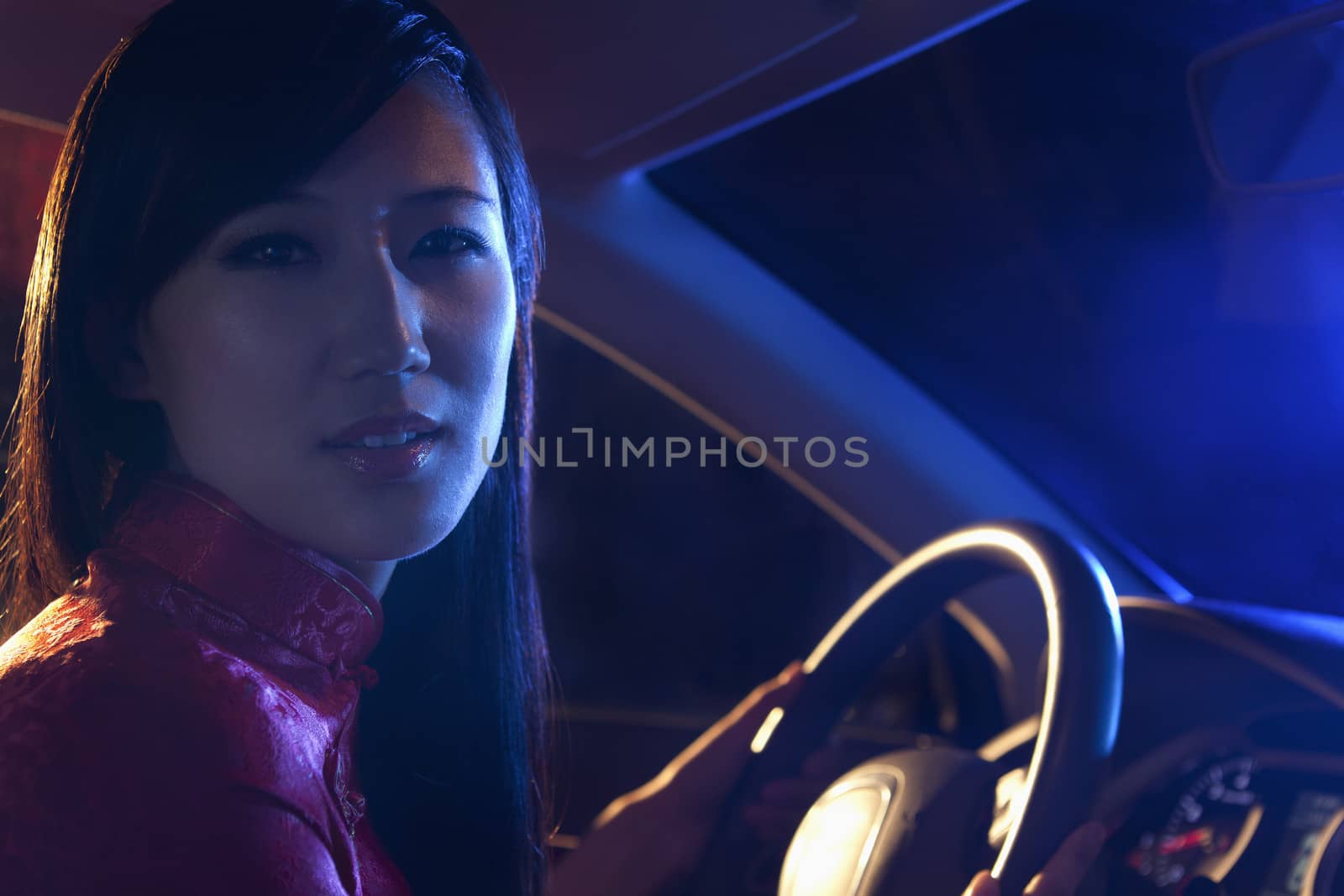 Portrait of young, beautiful woman in traditional clothing driving at night in Beijing by XiXinXing