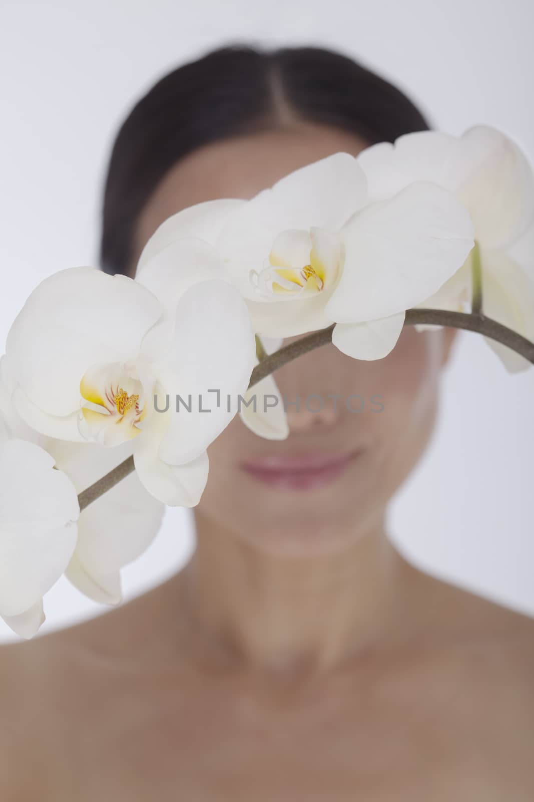 Shirtless smiling woman behind a bunch of beautiful white flowers, obscured face, studio shot by XiXinXing