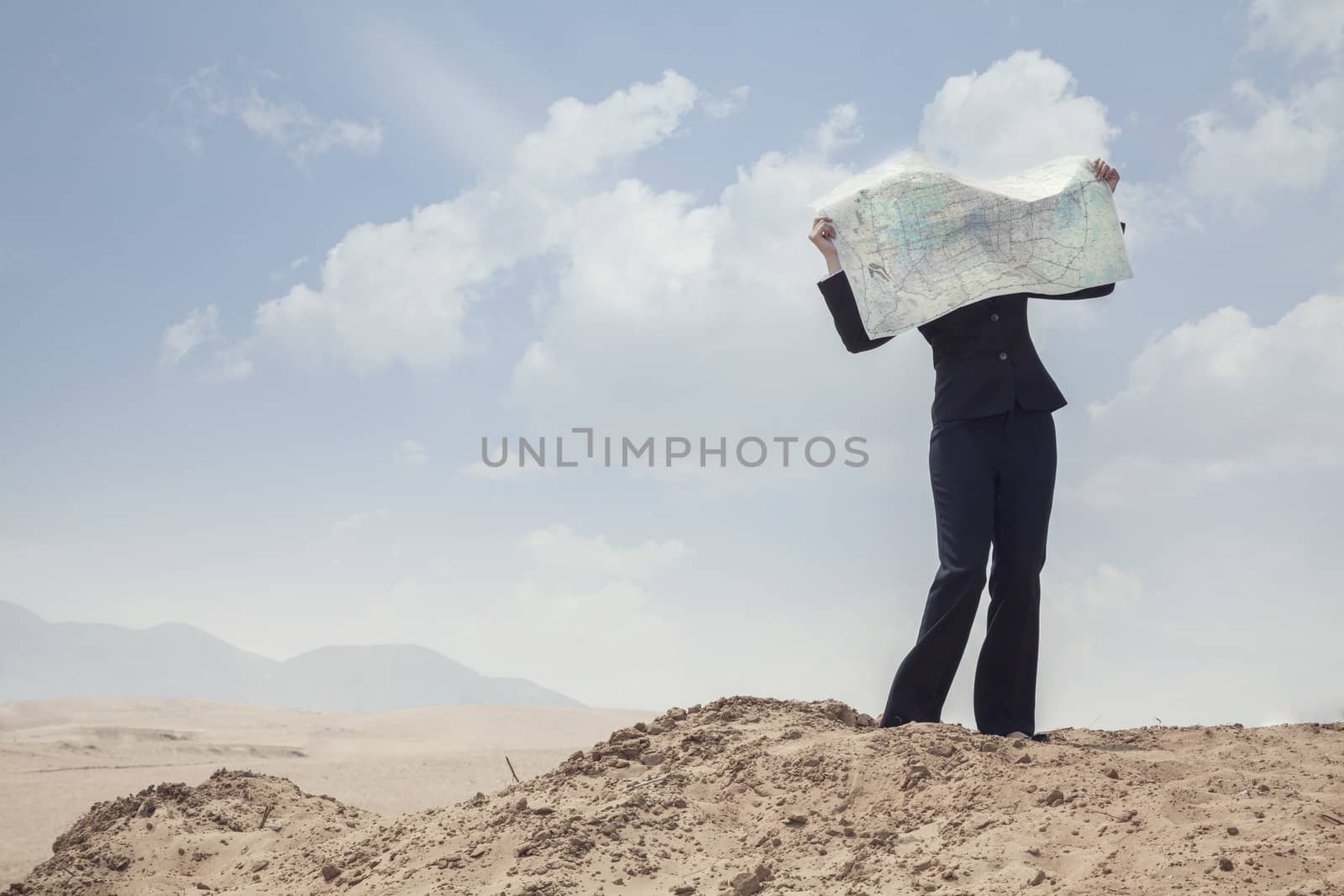 Young Businesswoman looking at a map in the middle of the desert 