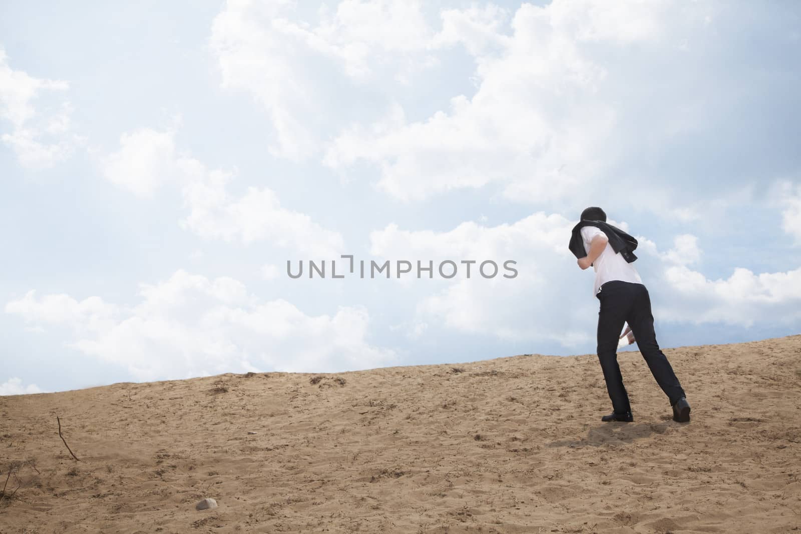 Young businessman lost and walking through the desert 