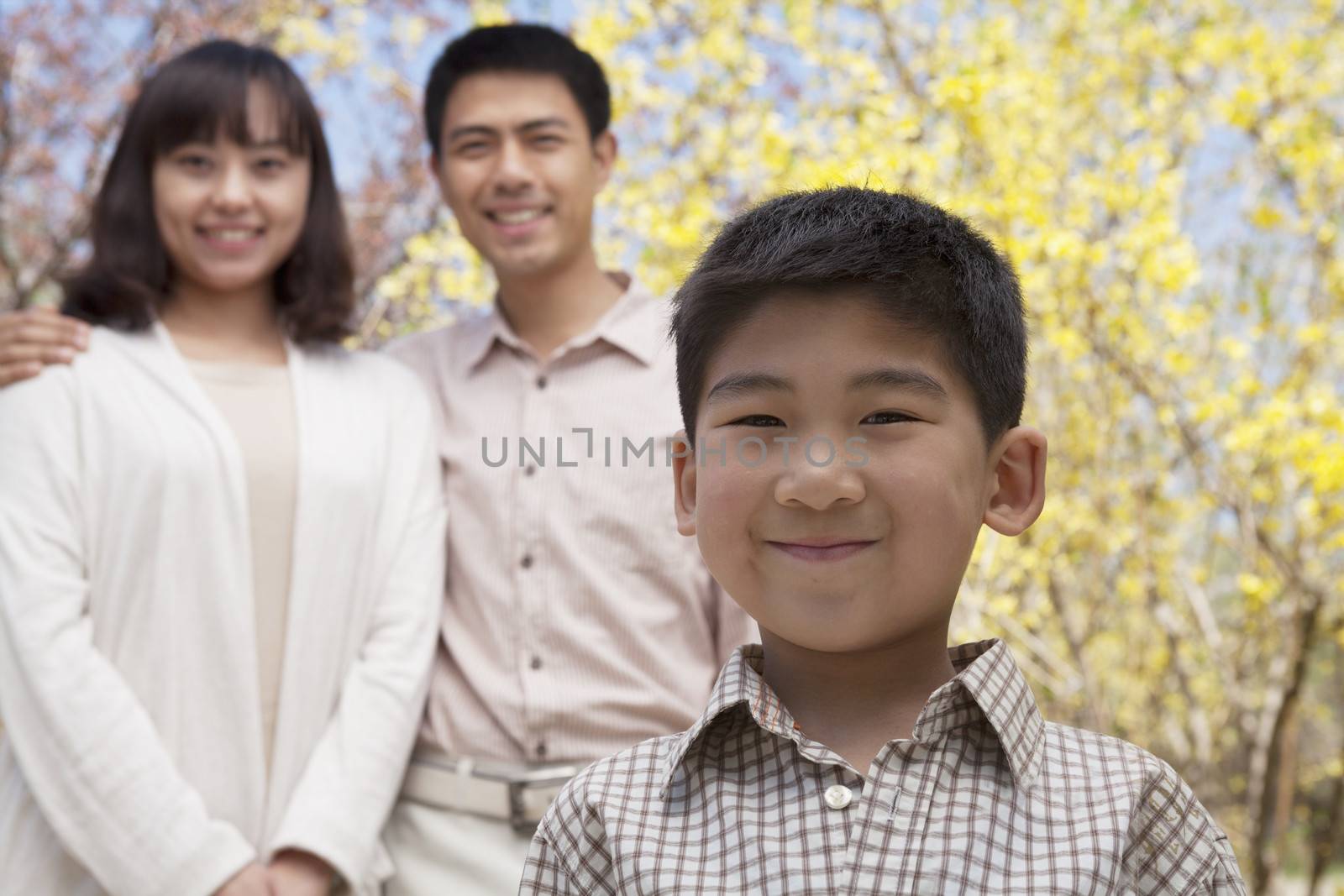 Portrait of happy smiling family in the park in springtime, Beijing, China by XiXinXing