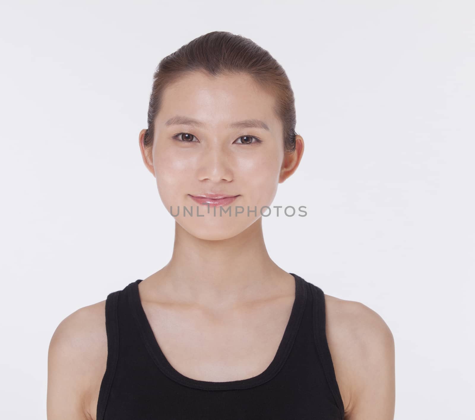 Portrait of smiling beautiful young woman in a black tank top, studio shot 