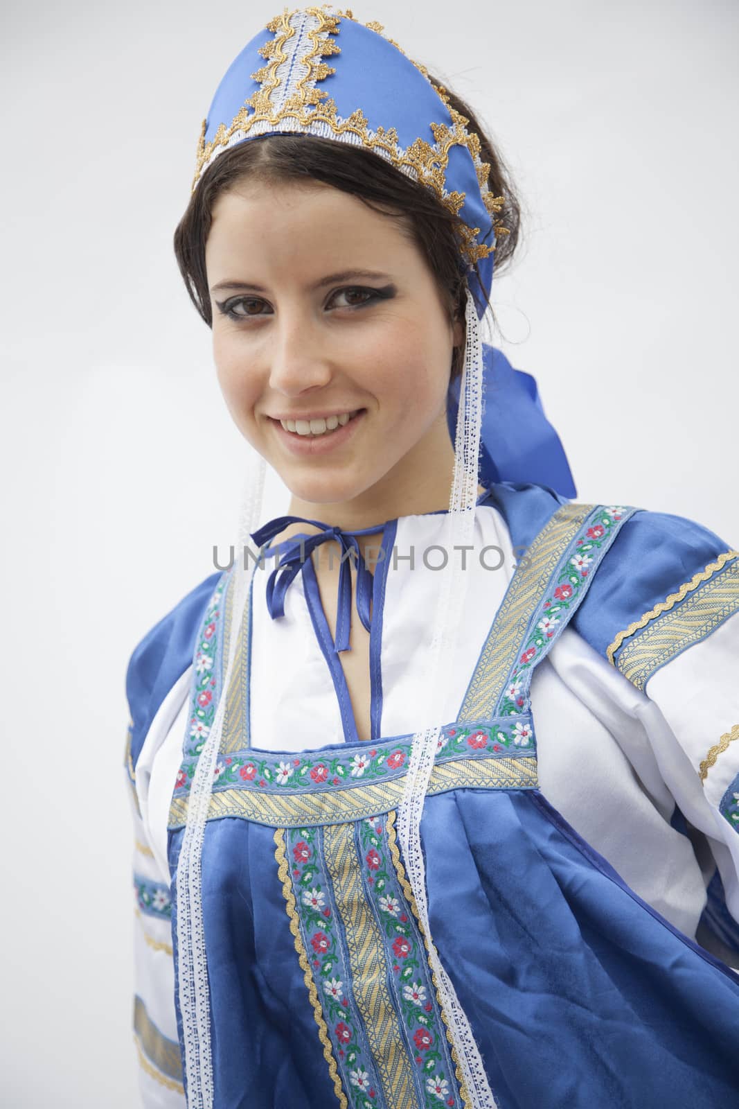 Portrait of young smiling woman in traditional clothing from Russia, studio shot