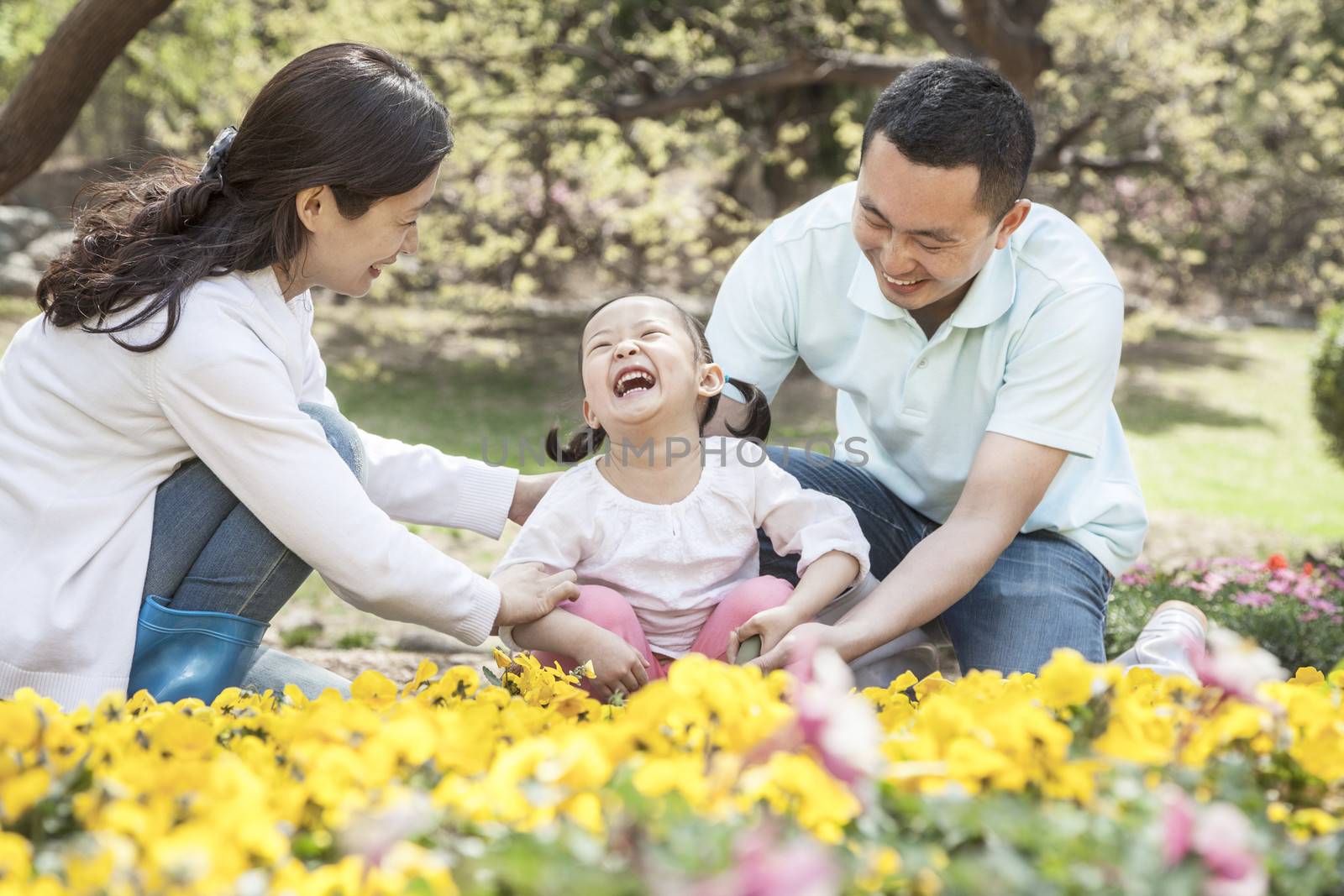 Family sitting in flower garden.