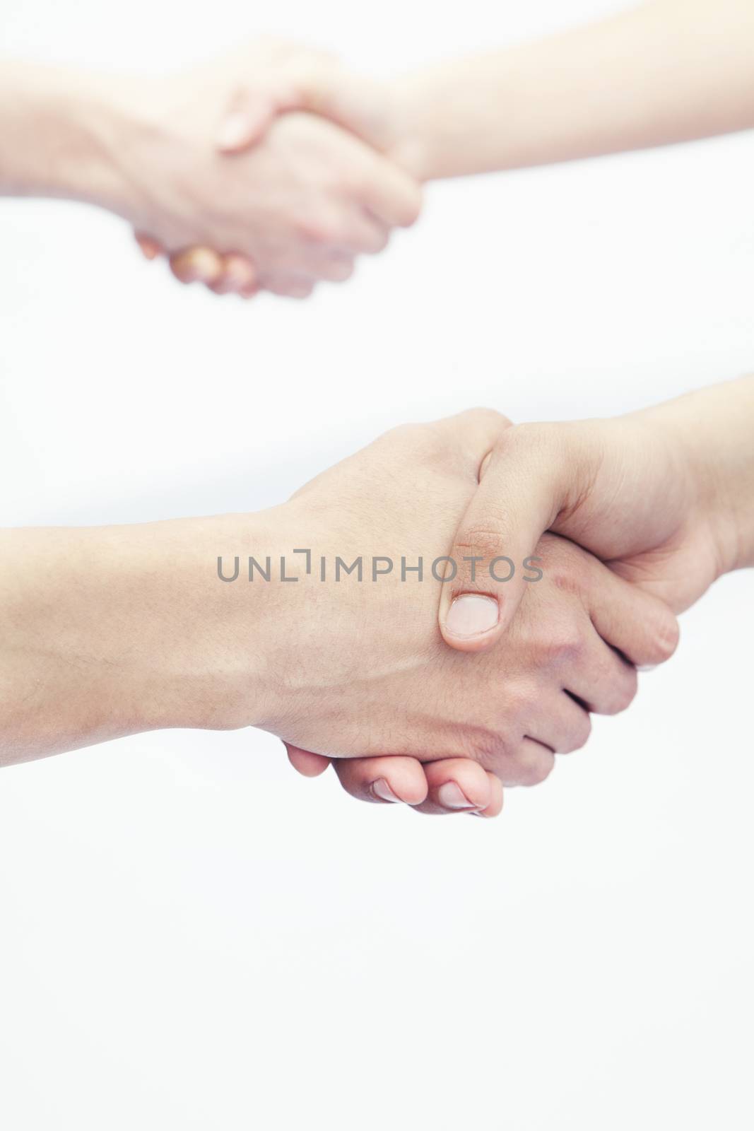 Four young people shaking hands, close-up, studio shot