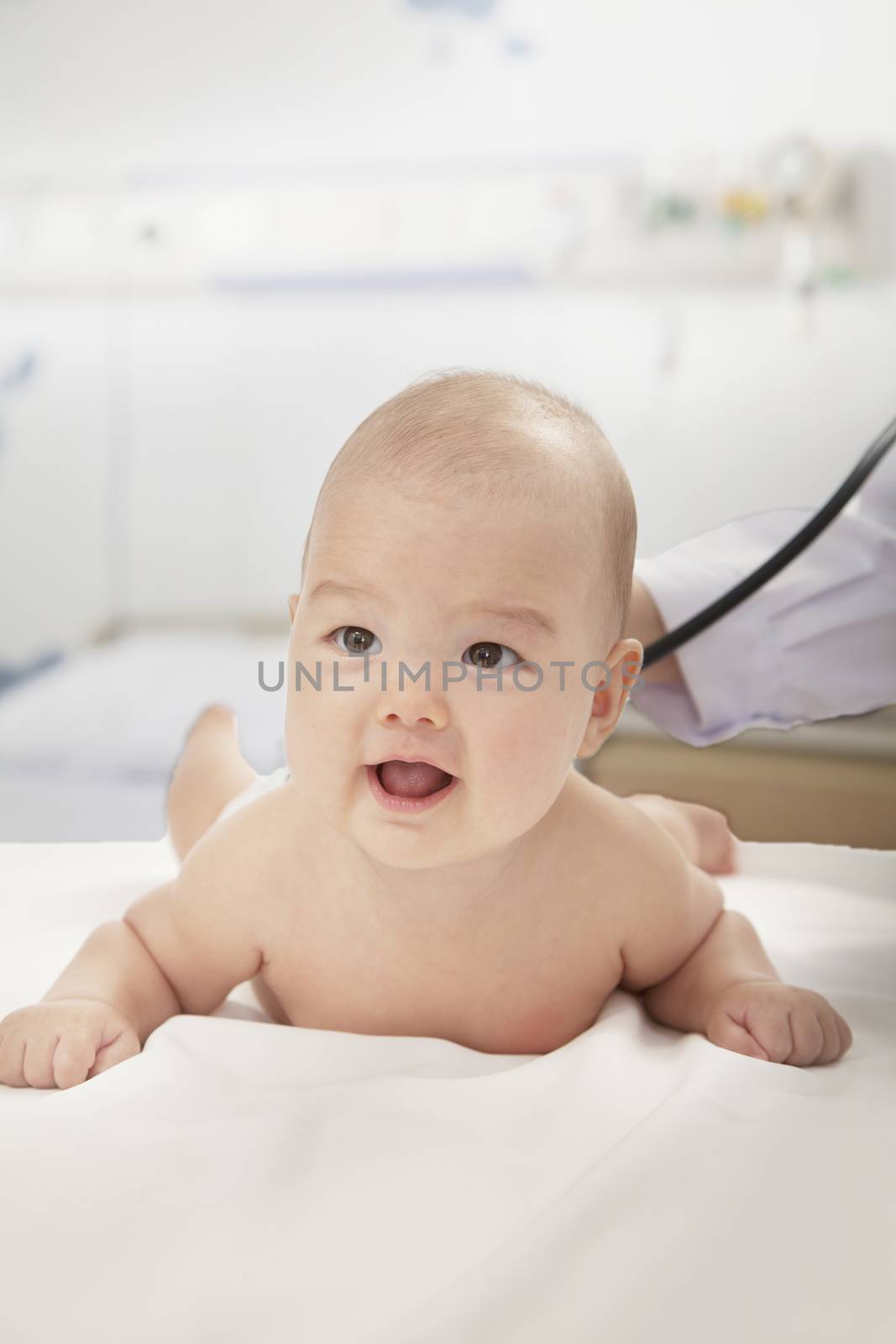 Close up of doctor checking baby's heart beat while the baby is lying down