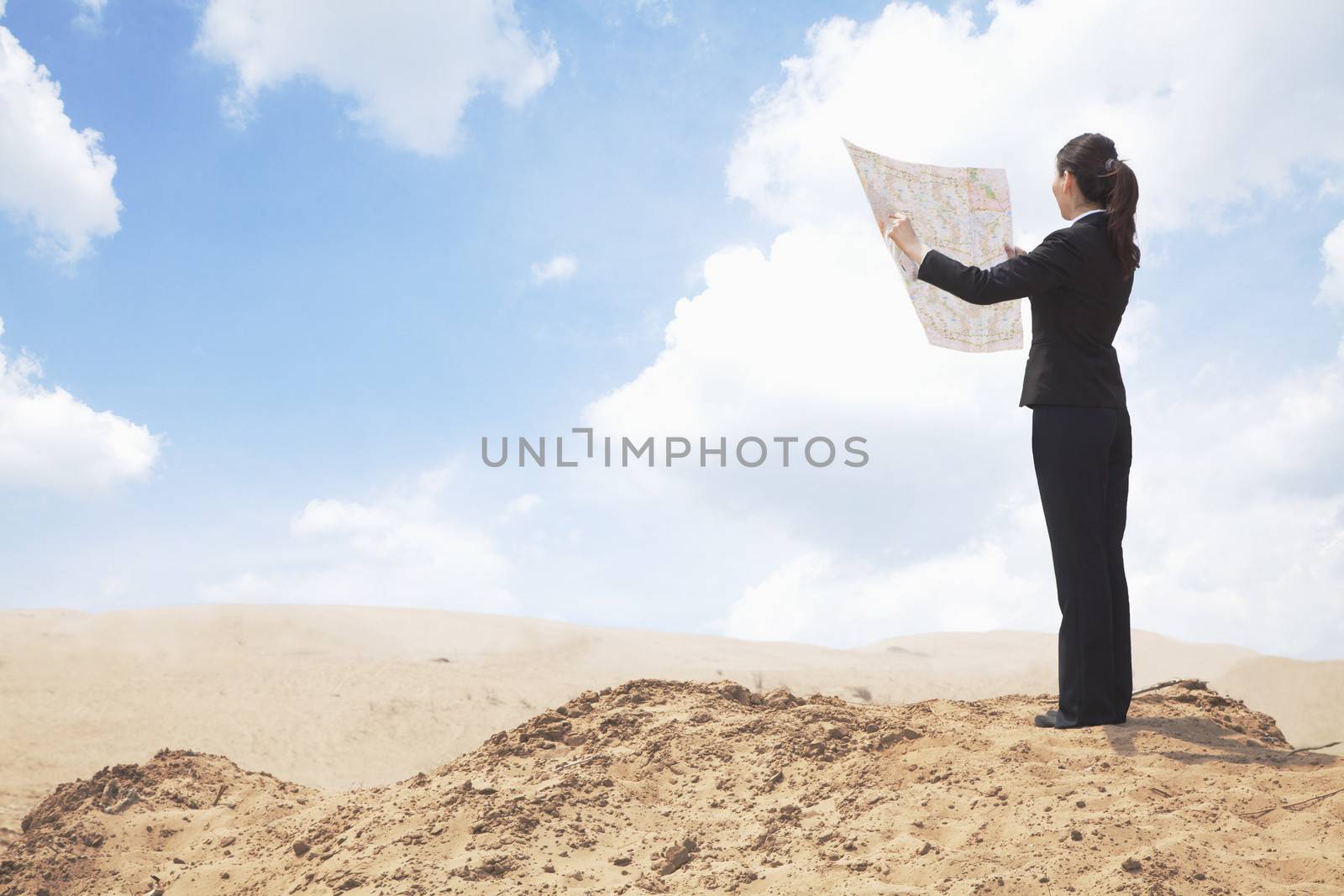 Young Businesswoman looking at a map in the middle of the desert  by XiXinXing