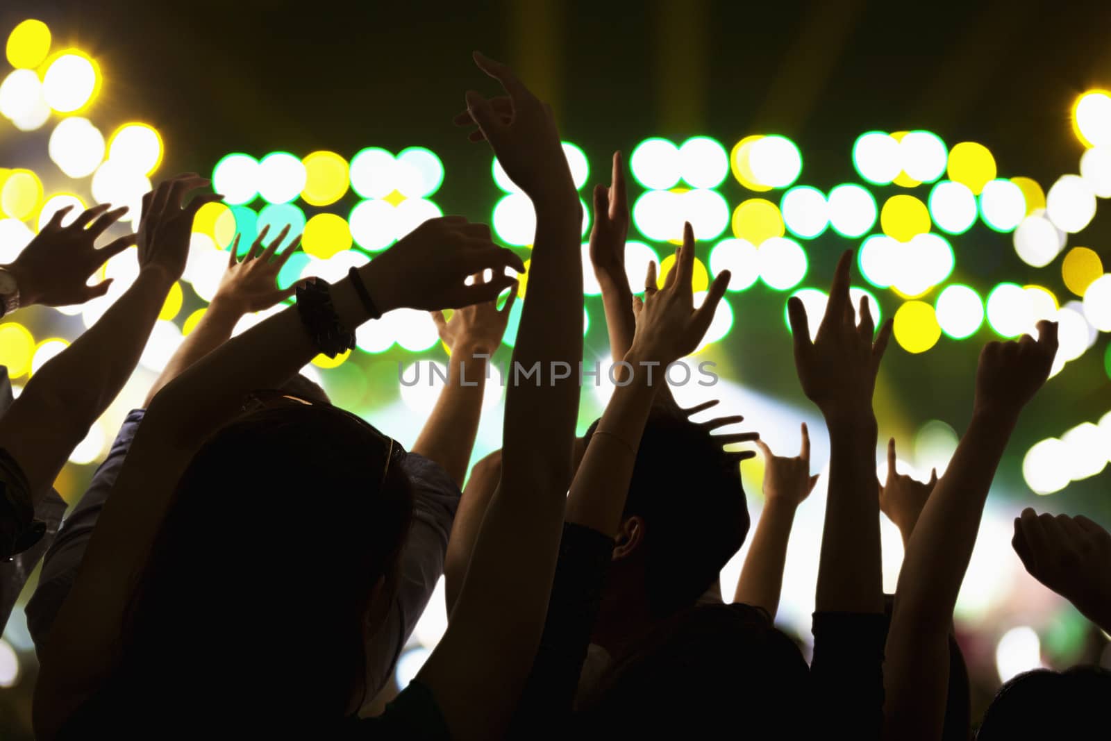 Audience watching a rock show, hands in the air, rear view, stage lights by XiXinXing