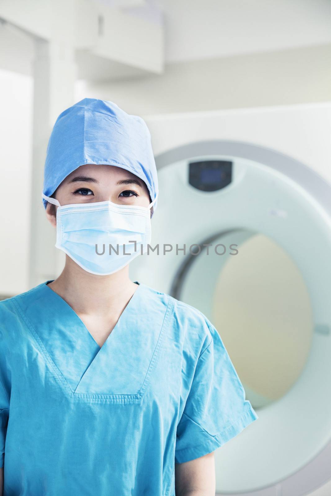 Portrait of young female surgeon wearing surgical mask in the operating room by XiXinXing