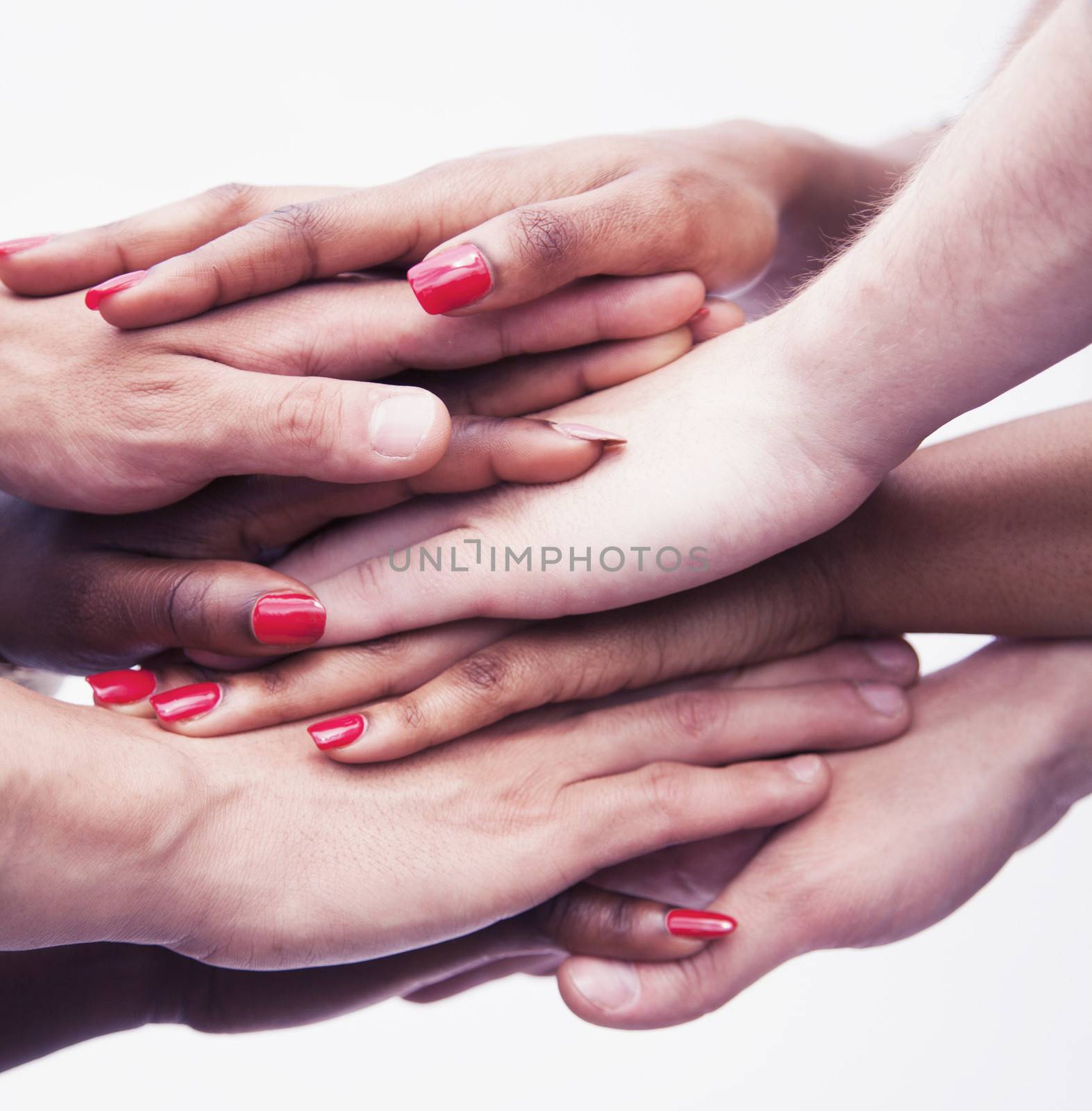 Close-up on a pile of hands on top of each other, multi-ethnic group of people, studio shot by XiXinXing