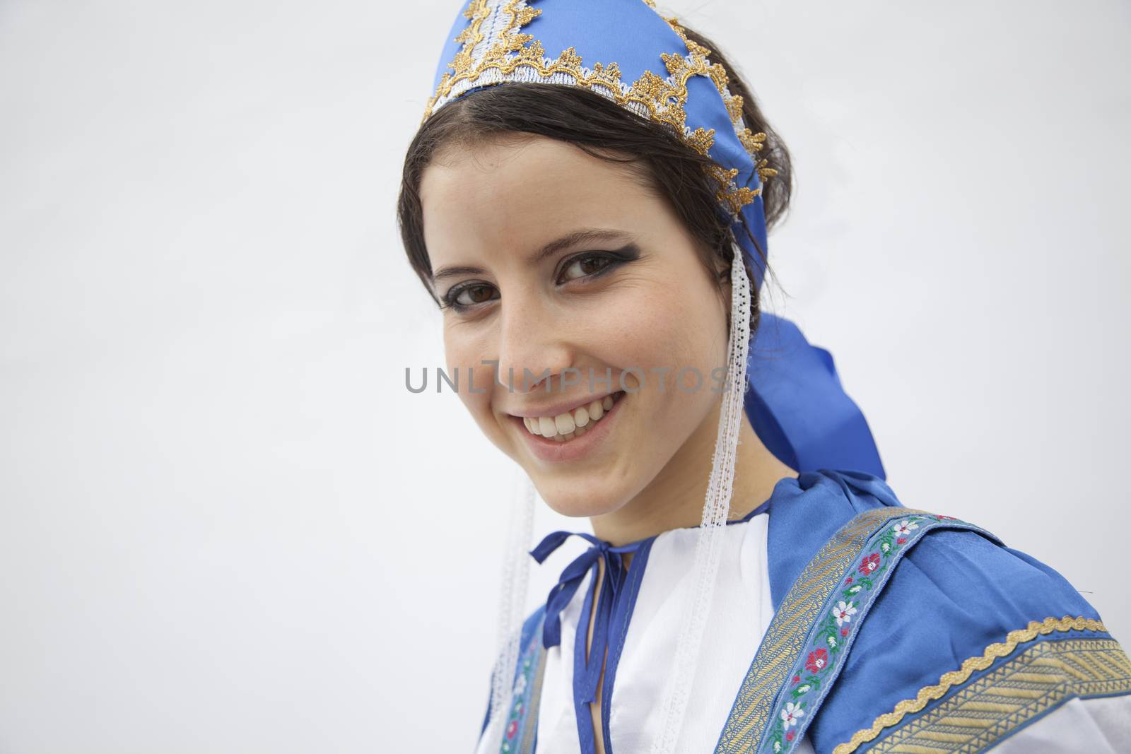 Portrait of young smiling woman in traditional clothing from Russia, studio shot