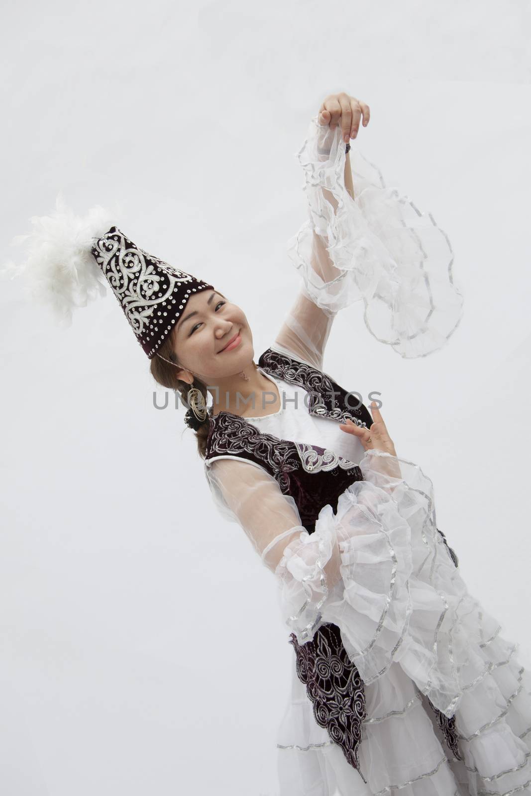 Portrait of young smiling woman dancing in traditional clothing from Kazakhstan, studio shot by XiXinXing