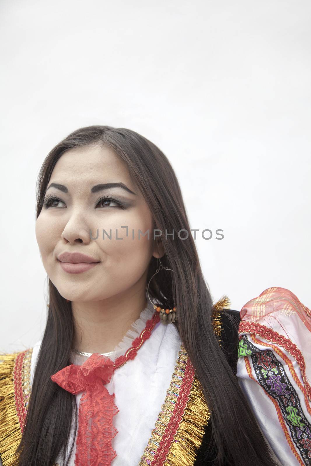 Portrait of young smiling woman in traditional clothing, studio shot