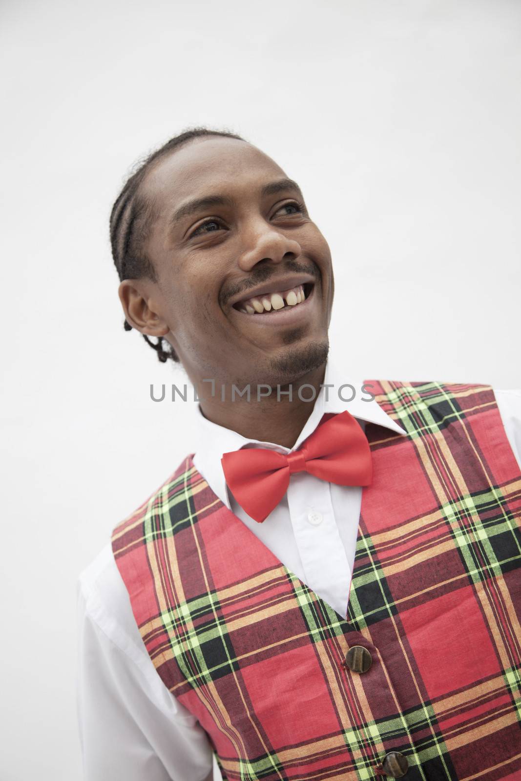 Portrait of young man in plaid vest and red bow tie, studio shot