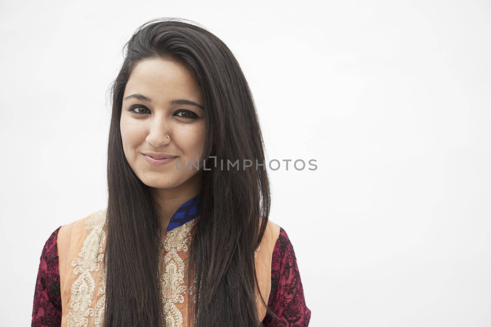 Portrait of smiling young woman wearing traditional clothing from Pakistan, studio shot