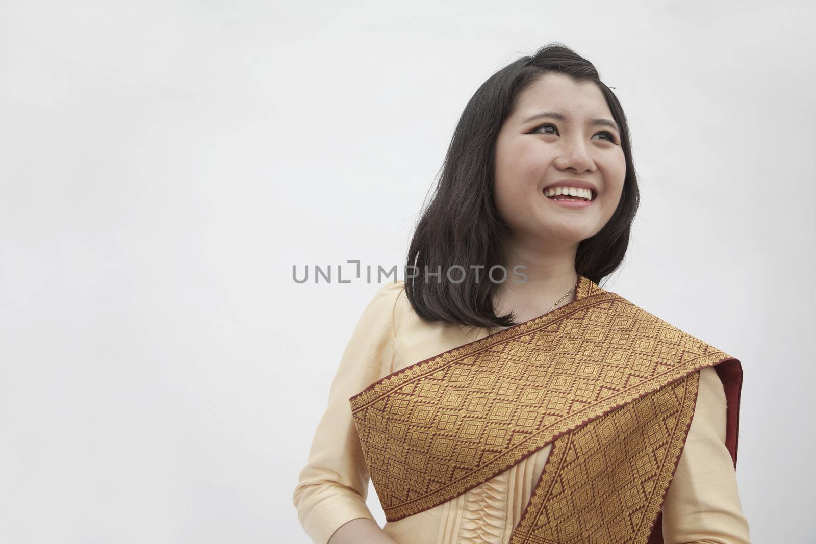 Portrait of smiling young woman in traditional clothing from Laos, studio shot by XiXinXing