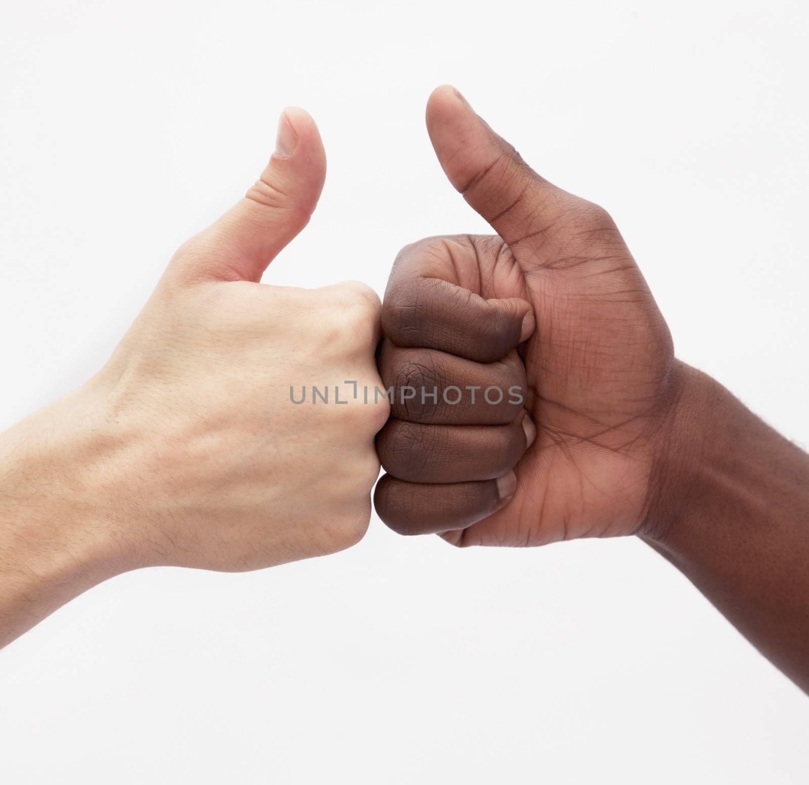 Two young men giving each other the thumbs up sign, close-up, studio shot by XiXinXing