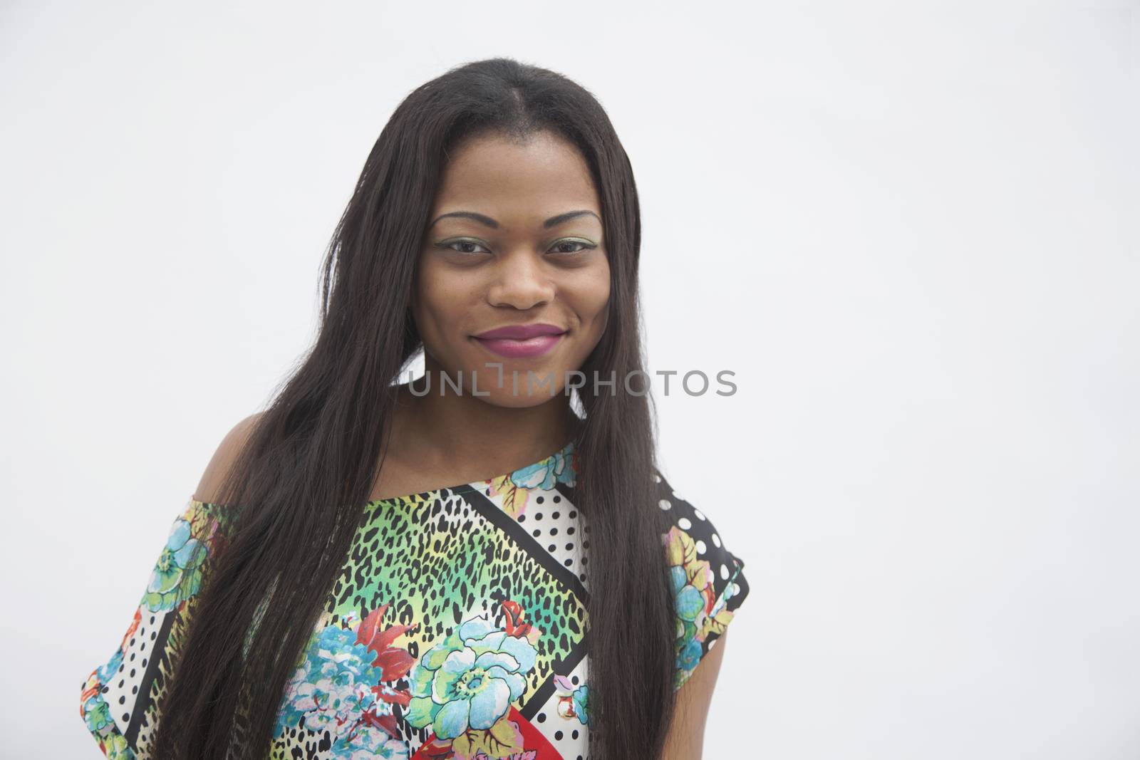 Portrait of young smiling woman with long hair in traditional clothing from Africa, studio shot by XiXinXing