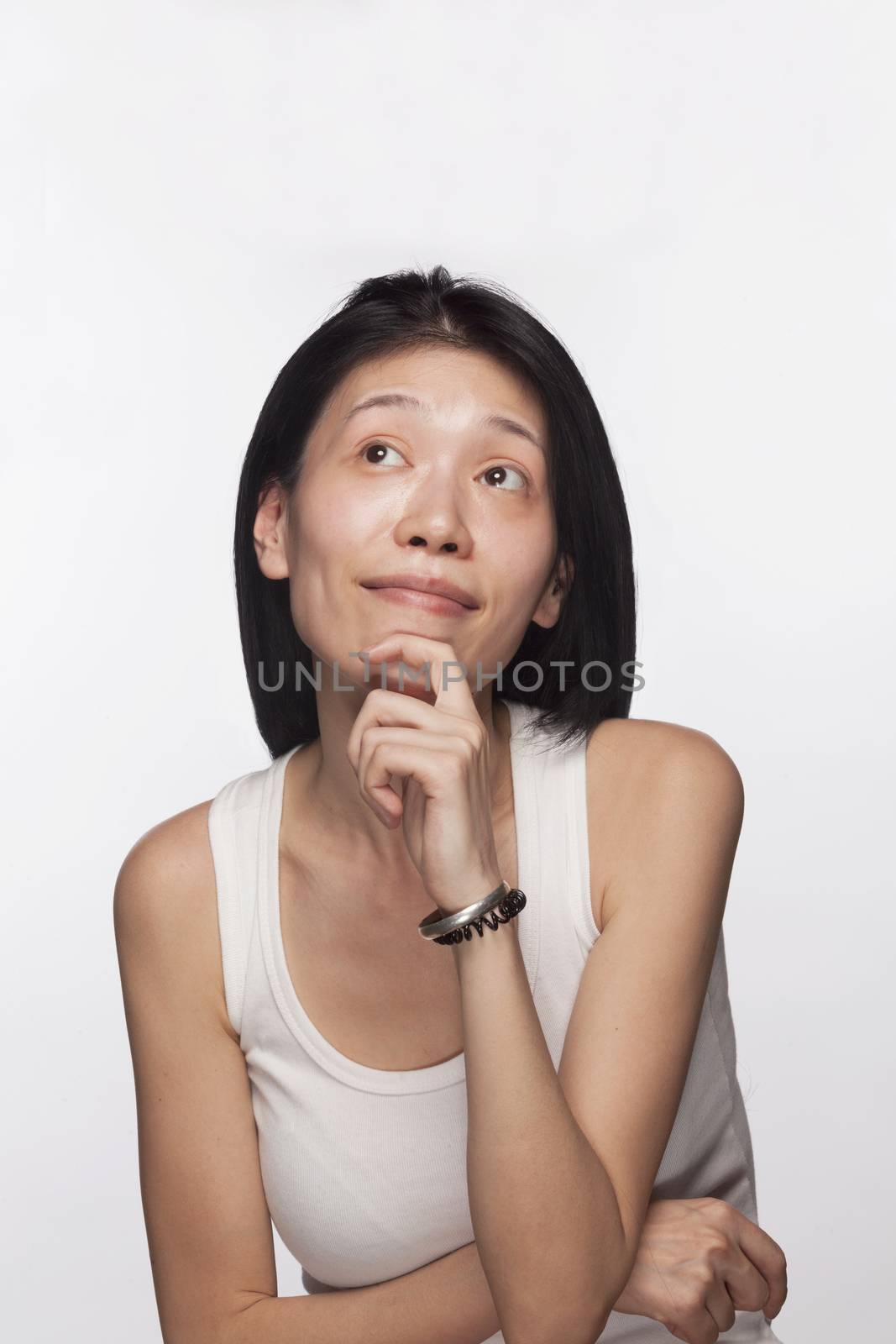 Portrait of woman with hand on her chin looking up in contemplation by XiXinXing