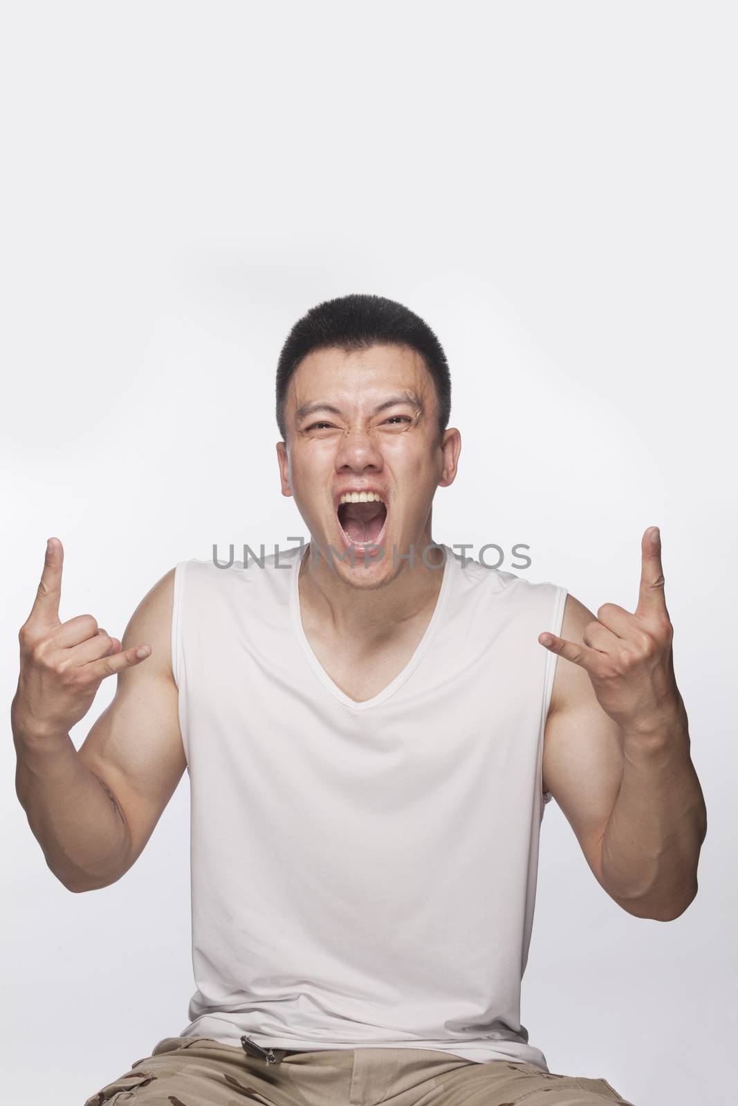 Excited man making hand sign with mouth open, studio shot by XiXinXing