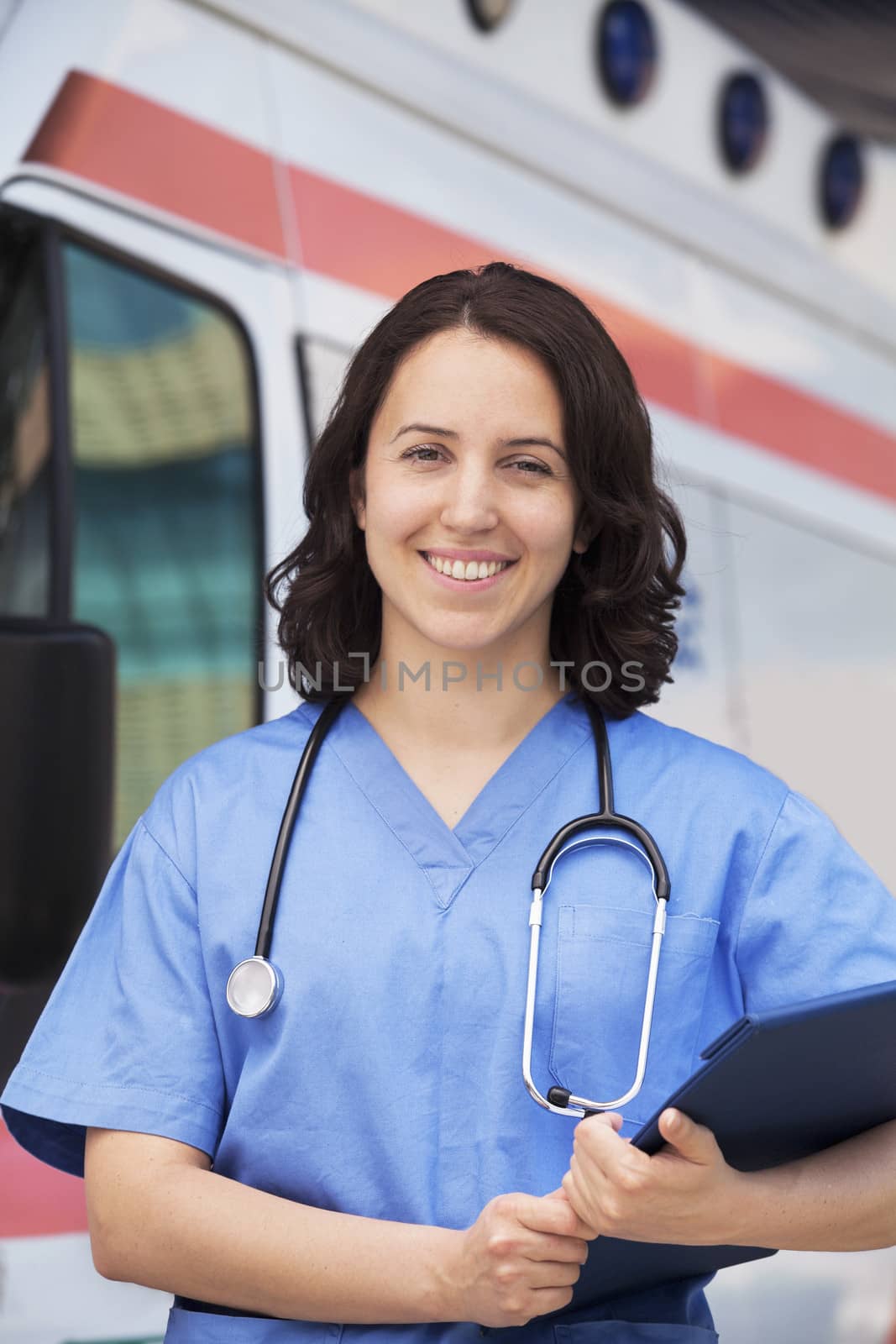 Portrait of smiling female paramedic in front of am ambulance