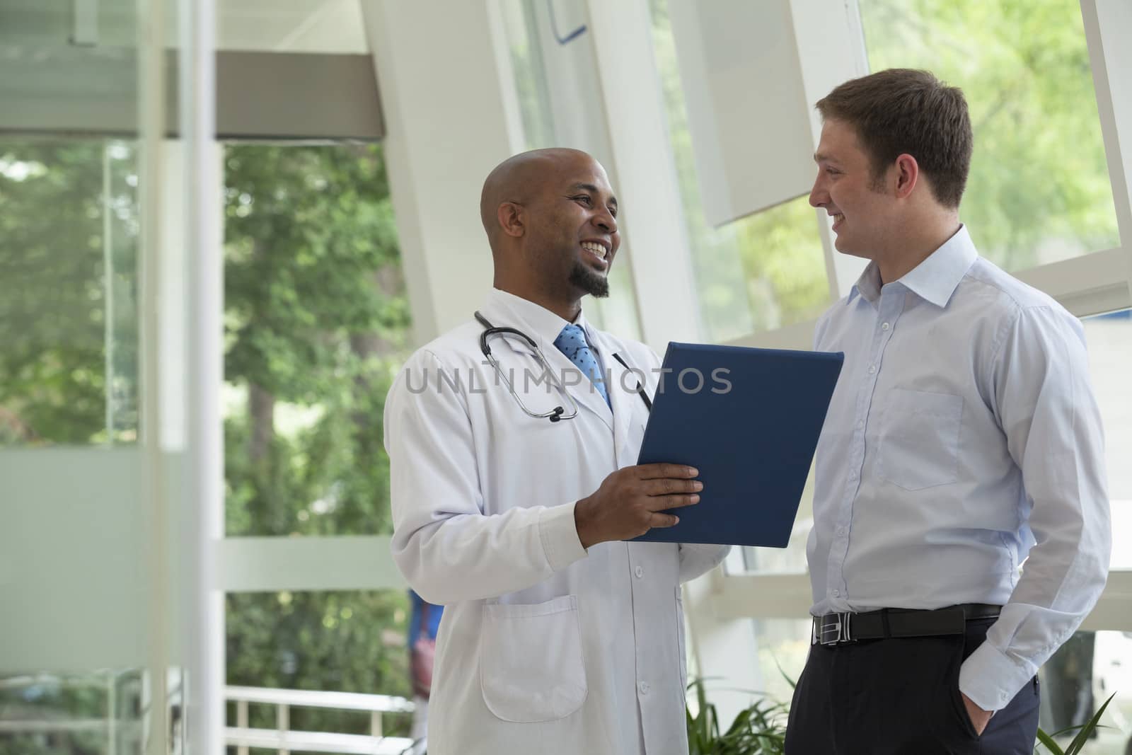 Doctor and patient smiling and discussing medical record in the hospital